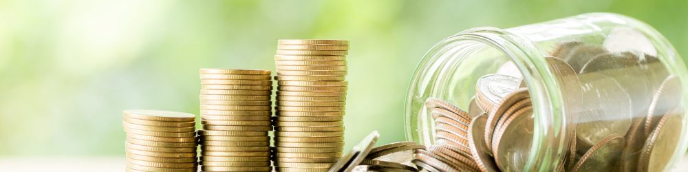 Coin on wooden table in front of green bokeh background. coins a concept of investment and saving moneys.